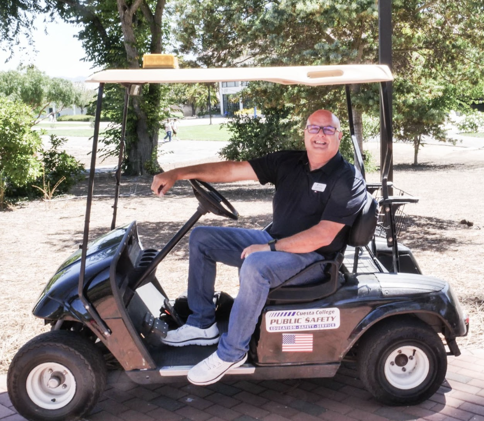 Cuesta College Police Chief Jesse Herring sits aboard his campus cruising golf cart. 