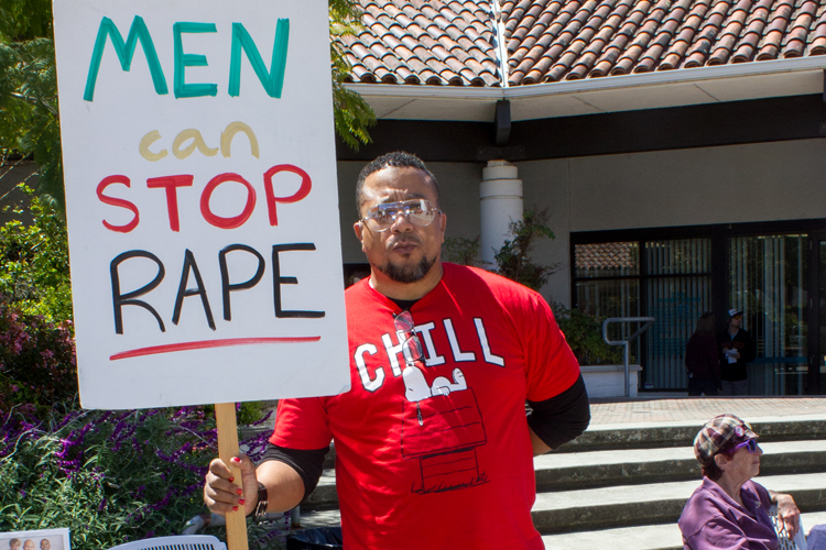 Marcher dawns sign against sexual assault and rape.