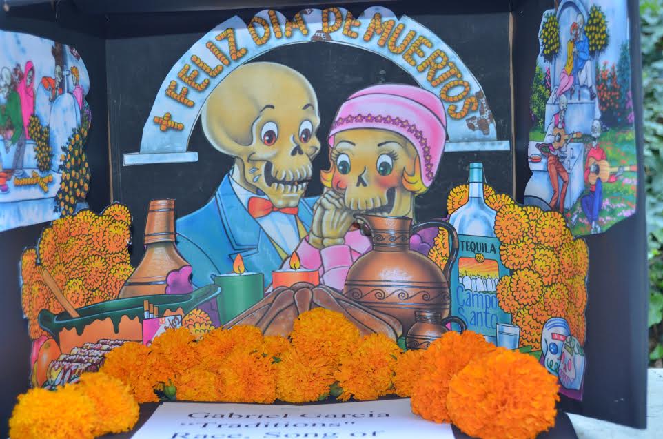 Poster board of Dia de los Muertos Altar. Photo by Hernandez Garcia - â€œThe altars were made by two of Lopezâ€™s Chicana and Chicano studies class,â€ said Sandy Hernandez, CC BY-SA 3.0, https://commons.wikimedia.org/w/index.php?curid=30054814