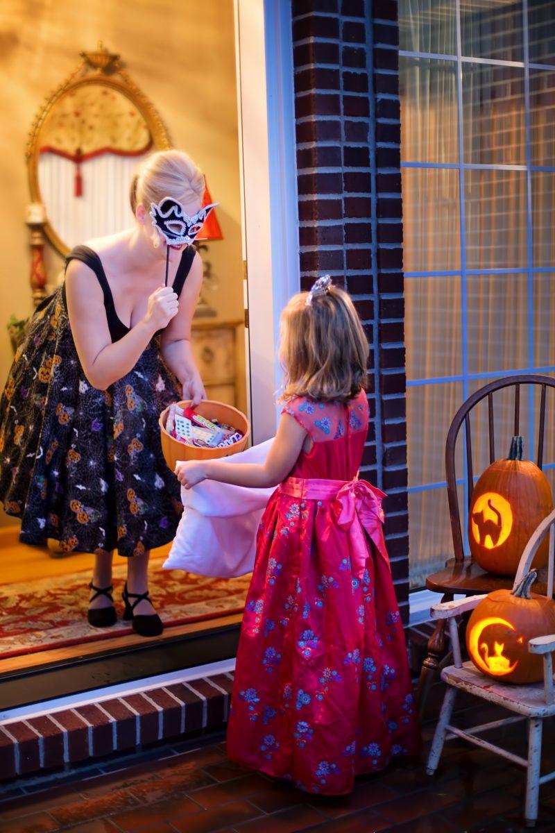 A little girl trick or treating as a princess. 