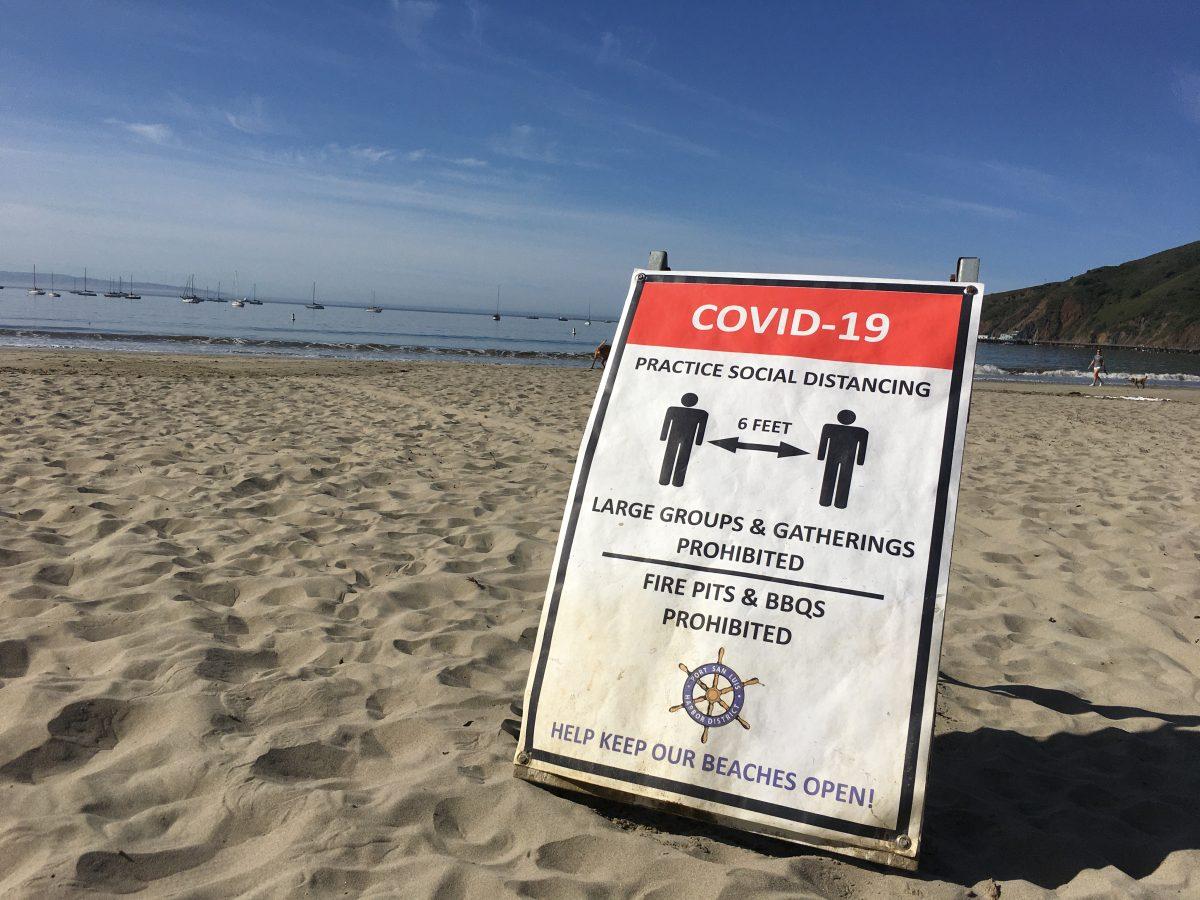 COVID-19 sign posted at Fishermanâ€™s Beach in Avila. Photo by Anna Paulson 