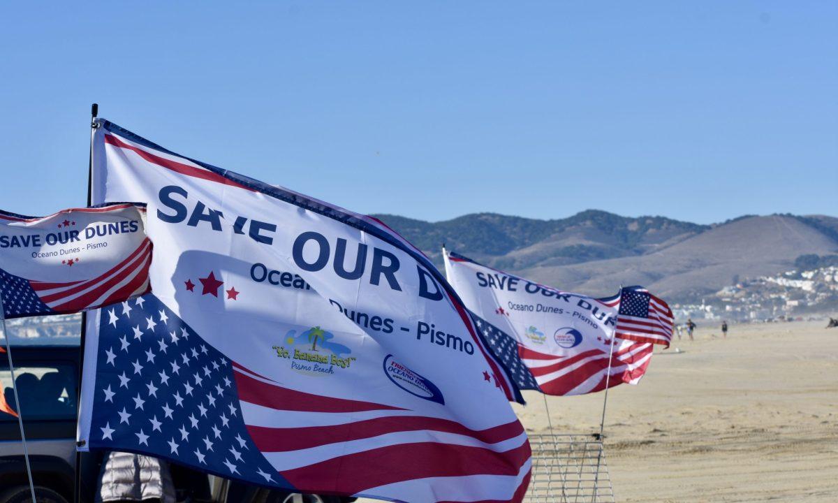 Flags labeled â€œSAVE OUR DUNESâ€ at the Oceano Dunes. Photo by Jonathan Apelado
