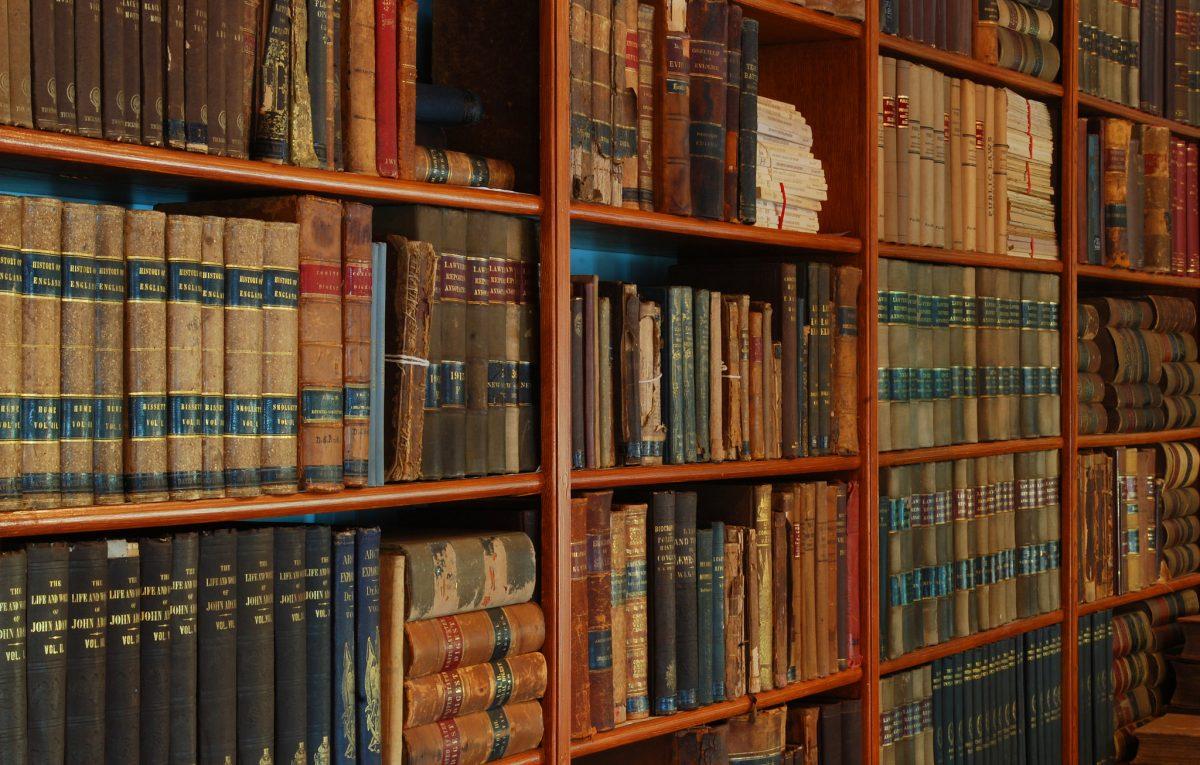 An antique bookshelf filled with modern literature. Photo by Barta IV