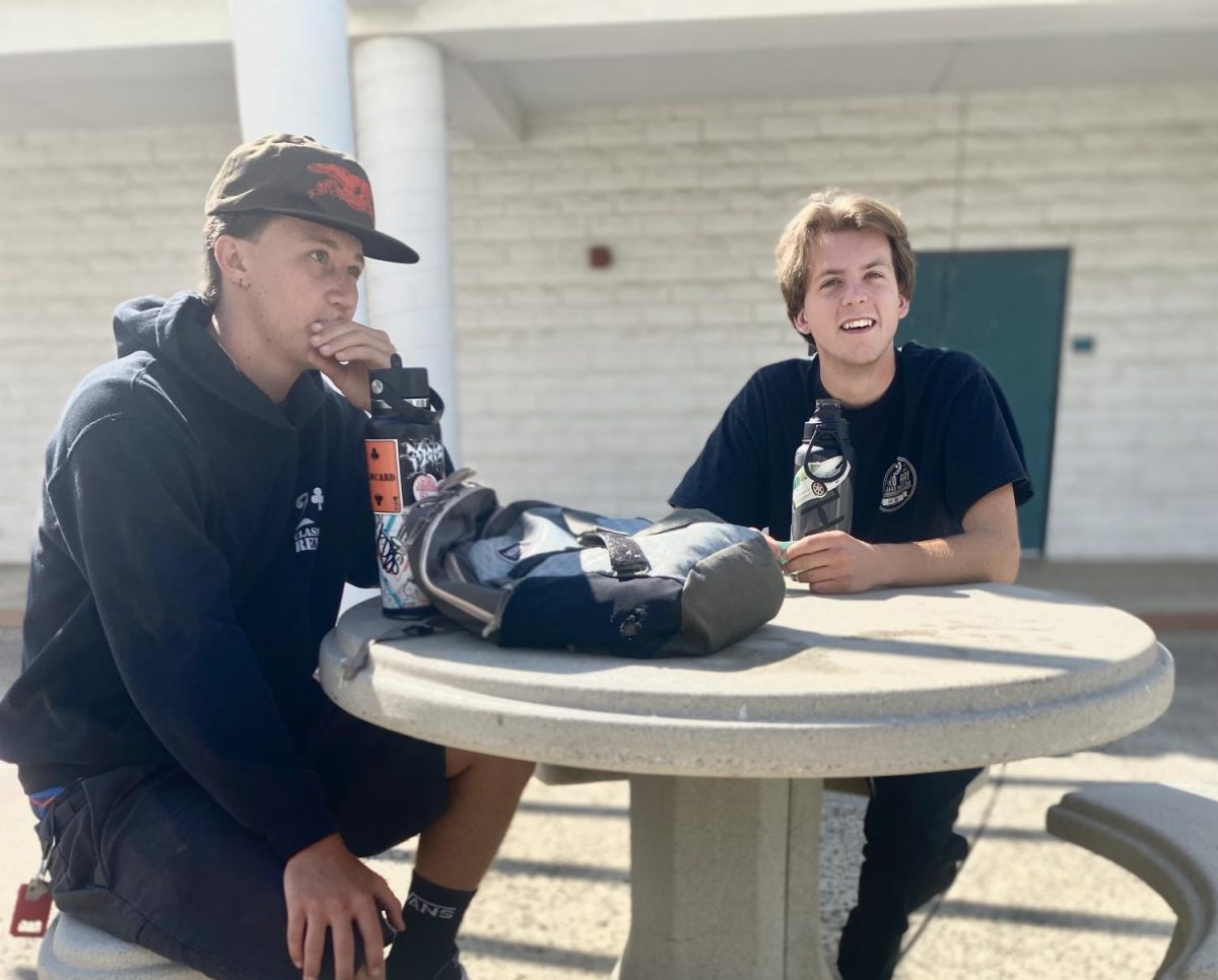 Two Cuesta College students chat while waiting for class outside the 7100 building on Aug. 12.