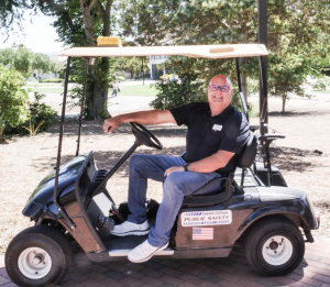 Cuesta College Police Chief Jesse Herring sits aboard his campus cruising golf cart. 
